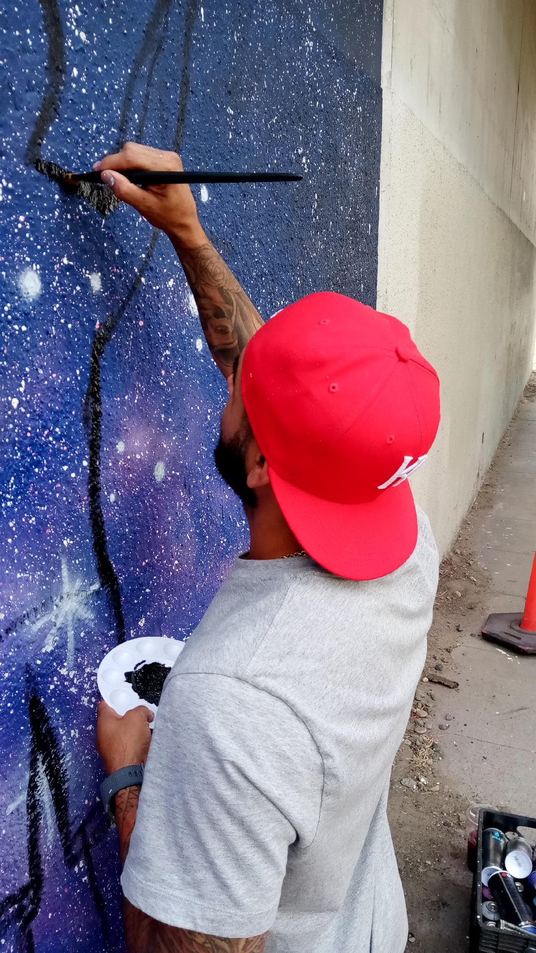 Applying paint with brush. Martin hopes this project will lead to more opportunities to work as an artist. Photo: Steve Newvine
