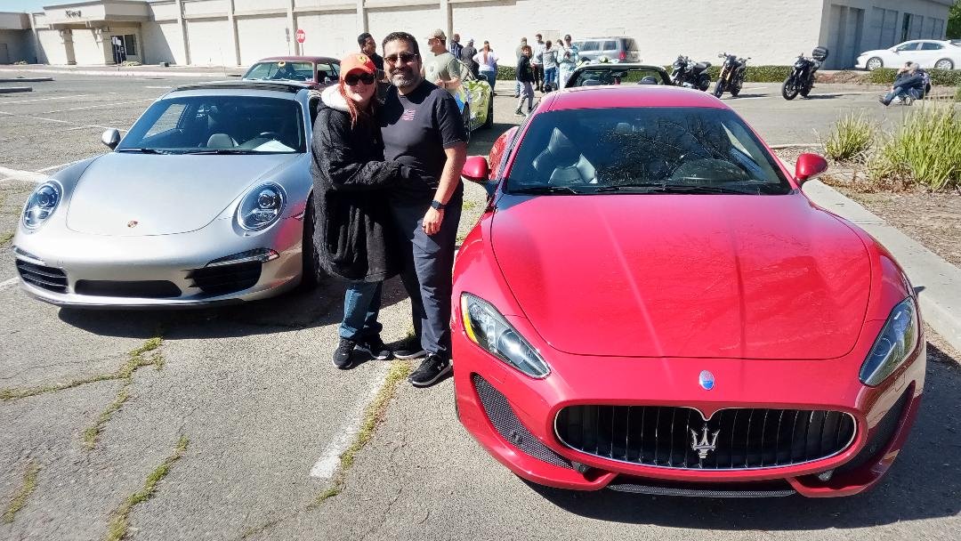 Tom and Emily Bustos along with their classic automobiles: a Maserati Granturismo and a Porsche 911. Photo: Steve Newvine