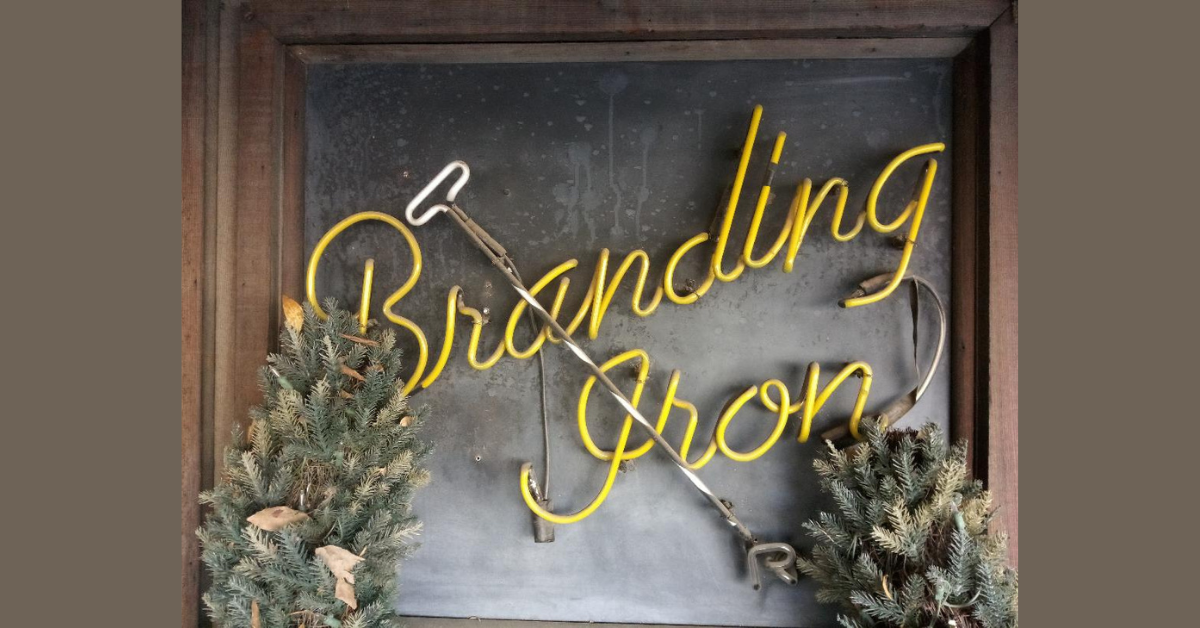 A smaller neon sign welcomes visitors to the Branding Iron entrance. Photo: Steve Newvine