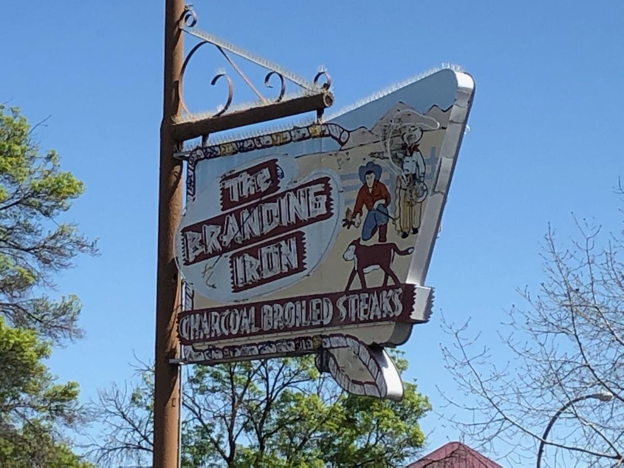 The iconic Branding Iron sign waits for the day the popular steak house reopens. Photo: Steve Newvine