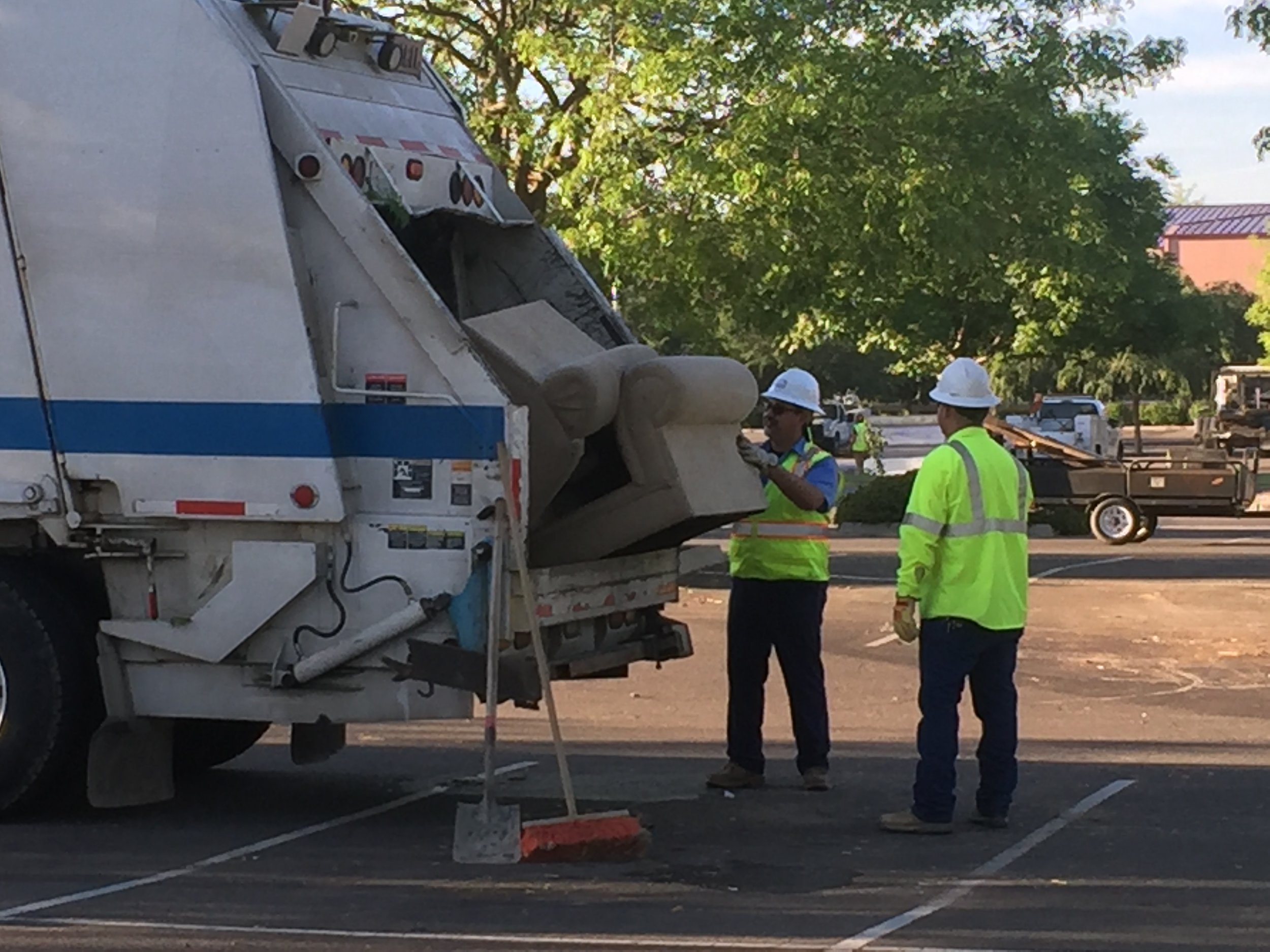 Just about anything not designated for a specific collection area ends up in a garbage truck. Here, workers are “feeding” a discarded couch to one of the city’s trucks. Photo- Steve Newvine