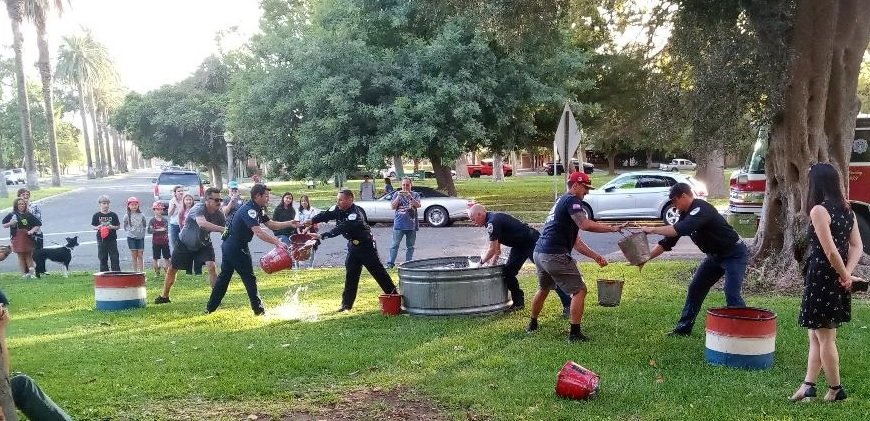 Members of the Merced Fire Department engage in a bucket brigade competition as part of the opening ceremony for the exhibit. Photo: Steve Newvine