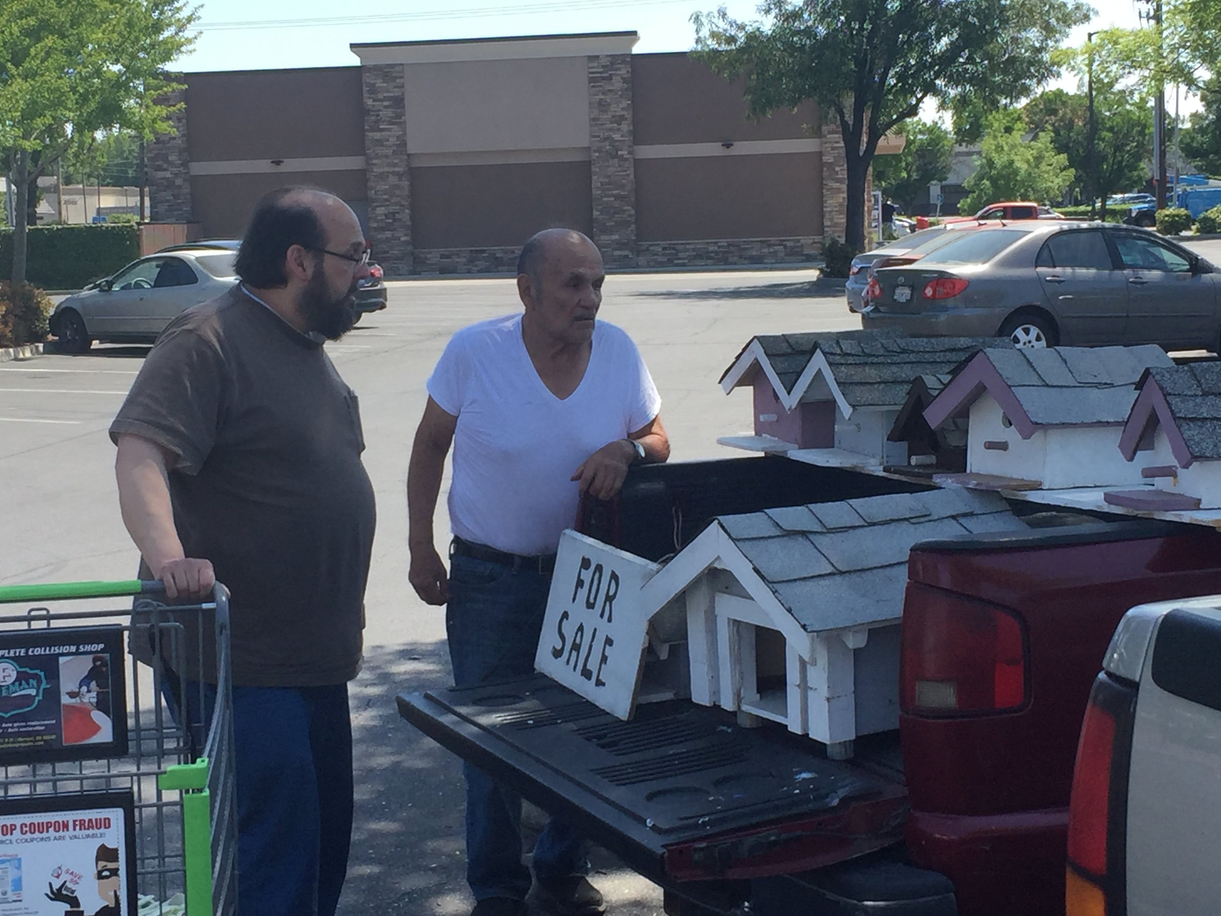 Keith Visher of Merced buys a birdhouse for his mother from Ben’s selection on the back of a pick-up truck. Photo: Steve Newvine